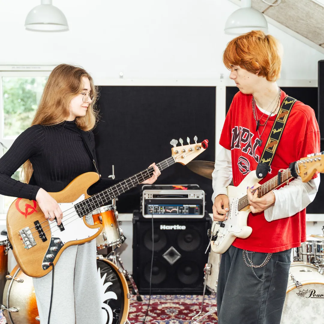 Dreng og pige spiller guitar på Danmarks bedste musikefterskole